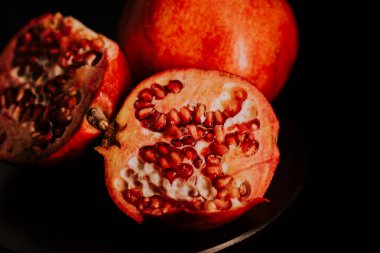 Nar meyvesi. Taze ve olgun nar siyah arka planda dönüyor. Organik Biyolojik Meyveler yakın plan. Diyet, diyet konsepti.