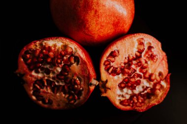 Nar meyvesi. Taze ve olgun nar siyah arka planda dönüyor. Organik Biyolojik Meyveler yakın plan. Diyet, diyet konsepti.