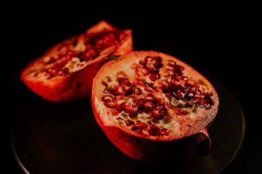 Nar meyvesi. Taze ve olgun nar siyah arka planda dönüyor. Organik Biyolojik Meyveler yakın plan. Diyet, diyet konsepti.