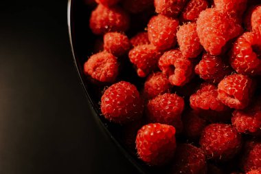 Taze, Olgun, sulu ahududu arka plan, berry yakından. Gıda arka plan. Gastronomi kavramı, organik gıda. Makro kırmızı ahududu meyve plaka siyah arka plan üzerine