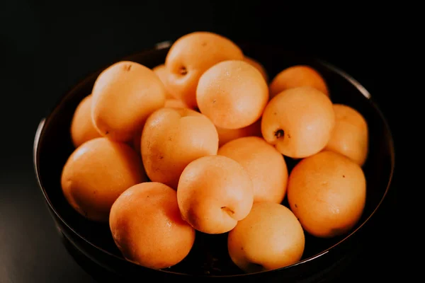 stock image Ripe apricots on a black background