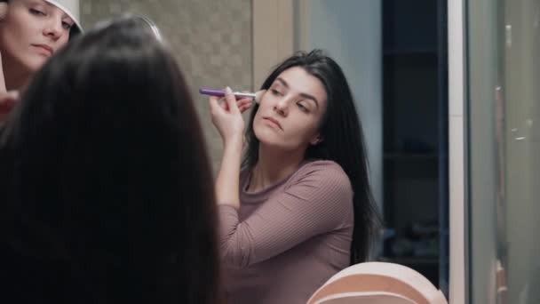 若い女性は顔の皮膚の世話をします 美容治療をしている 顔の皮膚にクリームをこすり 朝のルーチン パンピング ホームスパのコンセプト スキンケア化粧品コンセプト — ストック動画