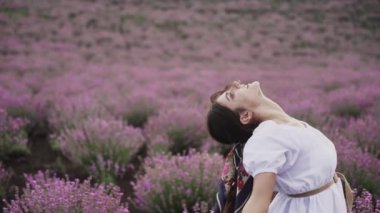 Lavanta tarlasında yürüyen güzel kadın beyaz elbiseli doğayı sever. Mutluluk masalı. 