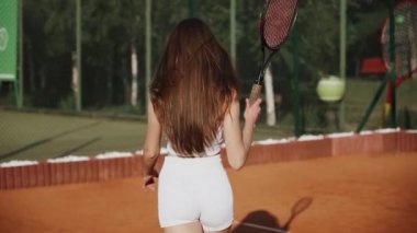 Kil spor sahasında tenis oynayan genç bir kadın. Tenis konsepti.
