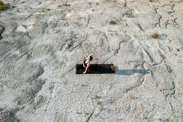 Woman doing yoga and standing on nails in the desert at sunset.The concept of yoga and standing on nails