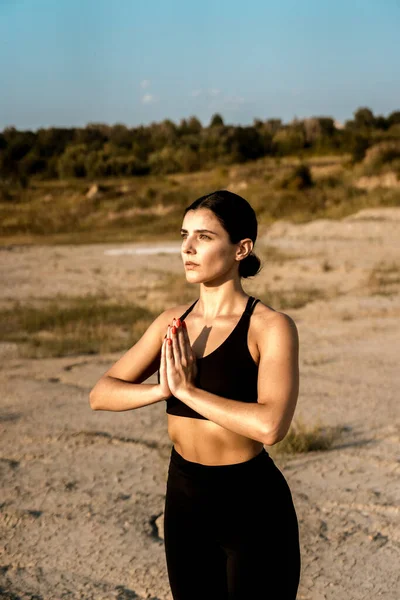 Woman doing yoga and standing on nails in the desert at sunset.The concept of yoga and standing on nails