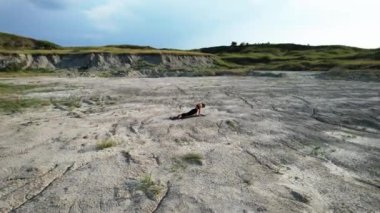 Gün batımında yoga yapan ve çölde çivilerin üzerinde duran bir kadın. Yoga ve çivilerin üzerinde durmak kavramı. Drone 4K çekti.