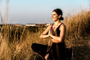 Gün batımında ağacın altında yoga yapan bir kadın. Yoga kavramı. 