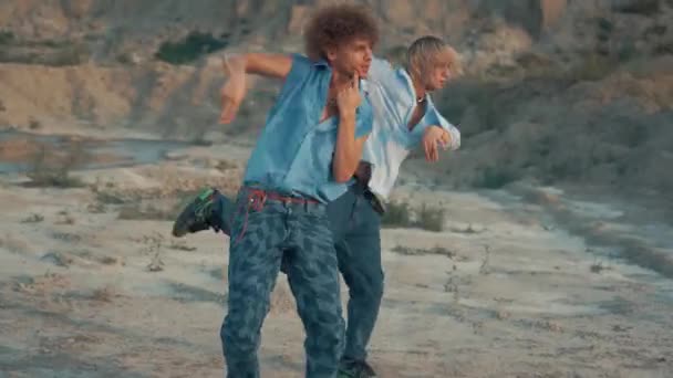 2人の男ダンサーが夕暮れに砂漠で現代ダンスを踊る — ストック動画