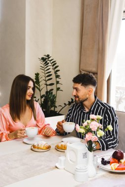 Genç aşık bir çift oteldeki bir restoranda kahvaltı yapıyor. Otelde tatil kavramı.