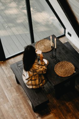 Bir kadın sonbaharda ormanda bir evde dinlenir ve meditasyon yapar. Geri çekilme ve meditasyon konsepti