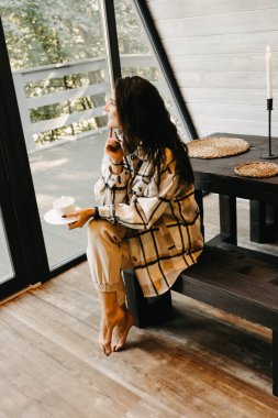 Bir kadın sonbaharda ormanda bir evde dinlenir ve meditasyon yapar. Geri çekilme ve meditasyon konsepti