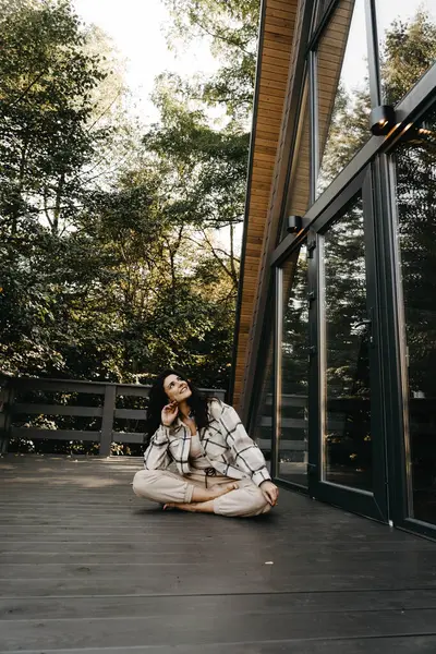 A woman rests and meditates in a house in the forest in autumn. Retreat and meditation conceptlt