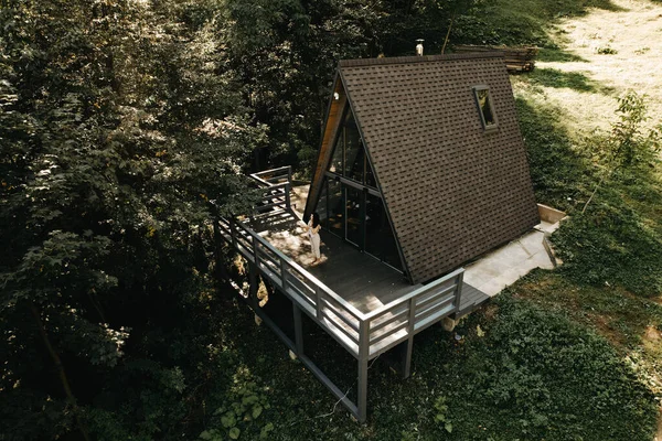 A woman rests and meditates in a house in the forest in autumn. Retreat and meditation conceptlt