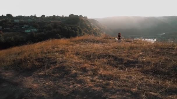 サンライズ山頂で瞑想する若いフィットネス女性 ドローン映像 — ストック動画