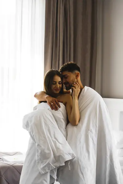 Couple in love posing in blankets in a hotel room in the mountains. Concept for a vacation in the mountains