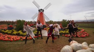 Kostüm giymiş bir grup dansçı Cadılar Bayramı dansı yapıyor.