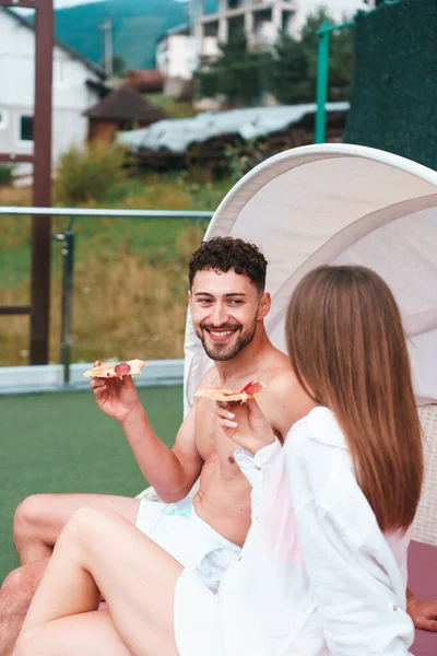 Couple enjoying a vacation in the mountain eating pizza and drinking beer