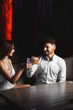 Birbirine aşık bir çift kokteyl içer ve gece terasta nargile içer. Gece hayatı konsepti