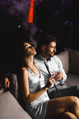 Birbirine aşık bir çift kokteyl içer ve gece terasta nargile içer. Gece hayatı konsepti
