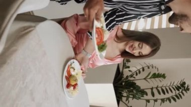 Birbirine aşık bir çift sabahları açık büfe sırasındaki bir restoranda kahvaltı eder. Otelde kahvaltı mı? Otelde rahatlama kavramı. Dikey video 