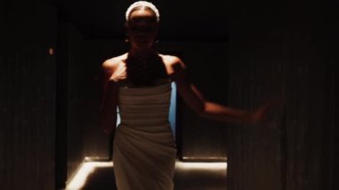 Bir düğün çekiminde beyaz elbiseyle poz veren esmer bir gelin. Düğün konsepti