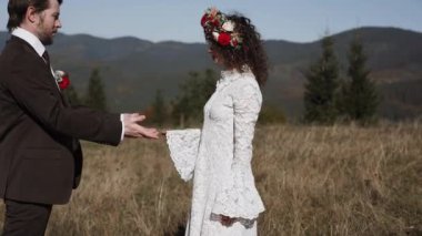 Otantik düğün çifti sonbaharda gün batımında dağlarda yürüyor. Düğün konsepti dağlarda. Sinema sahnesi 4K.