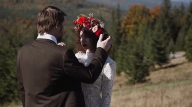 Otantik düğün çifti sonbaharda gün batımında dağlarda yürüyor. Düğün konsepti dağlarda. Sinema sahnesi 4K.