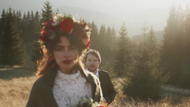 真正的新婚夫妇在秋天的日落时分走过高山 在山上举行婚礼的概念 电影框架4K — 图库视频影像