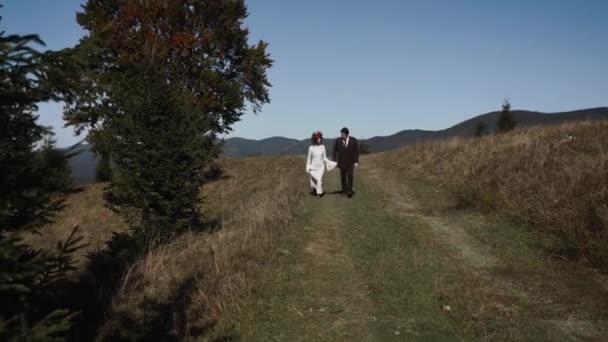 Authentisches Hochzeitspaar Das Herbst Bei Sonnenuntergang Durch Die Berge Wandert — Stockvideo