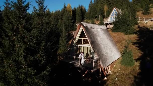 恋するカップルは 山の雰囲気のスカンジナビアの家のテラスにポーズします 結婚式のコンセプト 4Kについて — ストック動画