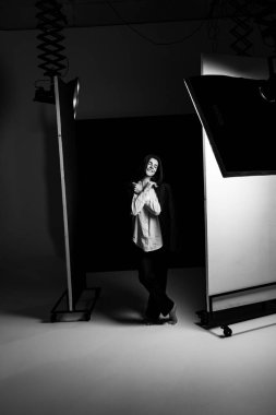 Profesyonel bir fotoğraf stüdyosunda siyah takım elbise ve beyaz gömlek içinde şık bir kız. Moda çekim konsepti