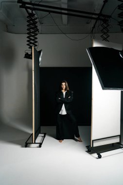 Profesyonel bir fotoğraf stüdyosunda siyah takım elbise ve beyaz gömlek içinde şık bir kız. Moda çekim konsepti