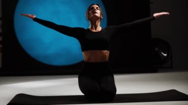Atletik kadın fotoğraf stüdyosunda yoga yapıyor. Yoga ve meditasyon konsepti. 4k