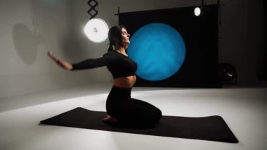 Atletik kadın fotoğraf stüdyosunda yoga yapıyor. Yoga ve meditasyon konsepti. 4k