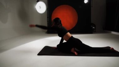 Atletik kadın fotoğraf stüdyosunda yoga yapıyor. Yoga ve meditasyon konsepti. 4k
