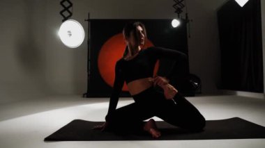 Atletik kadın fotoğraf stüdyosunda yoga yapıyor. Yoga ve meditasyon konsepti. 4k
