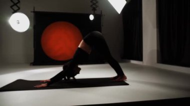 Atletik kadın fotoğraf stüdyosunda yoga yapıyor. Yoga ve meditasyon konsepti. 4k