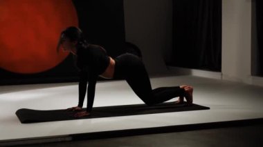 Atletik kadın fotoğraf stüdyosunda yoga yapıyor. Yoga ve meditasyon konsepti. 4k