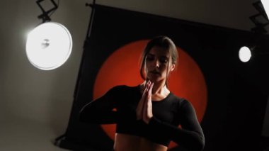 Atletik kadın fotoğraf stüdyosunda yoga yapıyor. Yoga ve meditasyon konsepti. 4k
