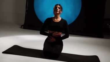 Atletik kadın fotoğraf stüdyosunda yoga yapıyor. Yoga ve meditasyon konsepti. 4k