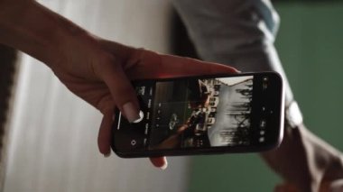Aşık bir çift kokteyl içer ve gün batımında otelin terasında fotoğraf çeker. Tatil konsepti. Dikey video