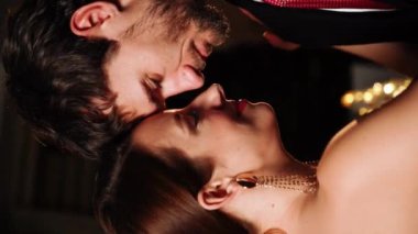 Birbirine aşık bir çift Noel gecesi bir restoranda dans eder. Noel kavramı. Dikey video.