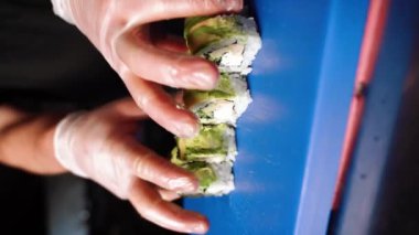 Suşi adam suşi hazırlıyor. Ellerinizi yakın tutun. Suşi ve ekmek hazırlama kavramı. Dikey video