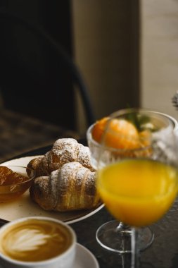 Dağlardaki otel balkonunda yeni yıl kahvaltısı. Kruvasan, meyve suyu ve mandalinalı kahve karlı dağların arka planında. Kış tatili kavramı