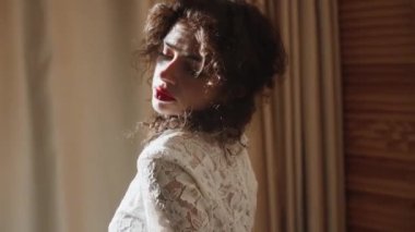 Gelinlik giymiş bir manken dumanlı ve güneşli bir odada poz veriyor. Moda düğün fotoğrafçılığı kavramı