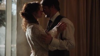 Birbirlerine aşık çiftler dumanda poz veriyorlar. Pencereden gelen güneş ışınlarıyla.