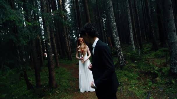 一位红头发的新娘在松树林中与新郎合影 童话般的婚礼夫妻结婚的概念 — 图库视频影像