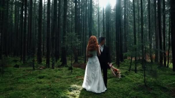 松の森でブドウと赤い髪の花嫁がポーズする おとぎ話のウェディングカップル ウェディングコンセプト — ストック動画