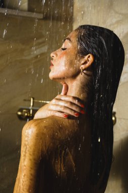 Genç ve güzel bir kadın duş alıyor. Vücut bakımı kavramı